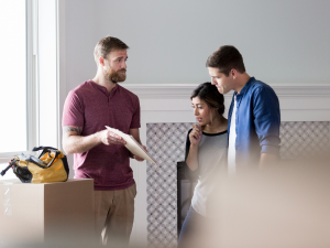 Plymouth Roofing expert explaining the benefits of different roofing materials to homeowners.