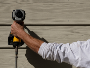 A professional Brooklyn Park siding contractor expertly replacing home siding.