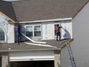 Professional Brooklyn Park siding contractors working on a house