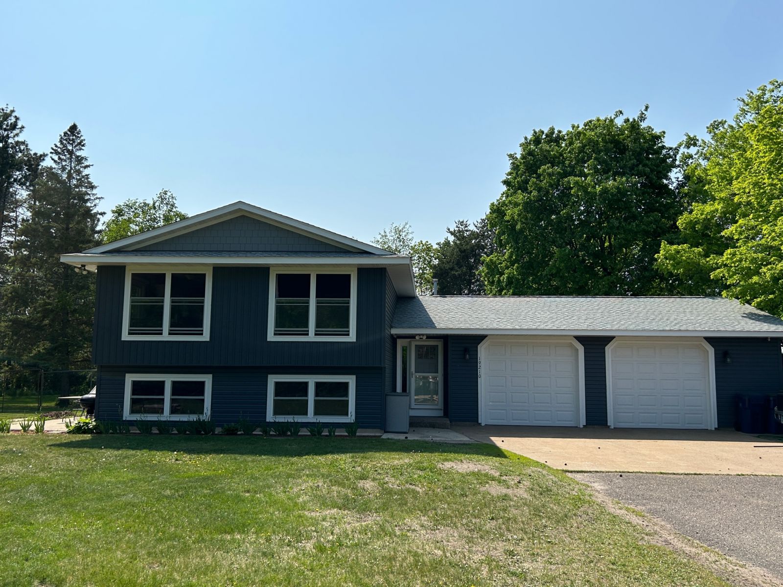 Completed dark siding on a split-level Minnesota home with an attached garage