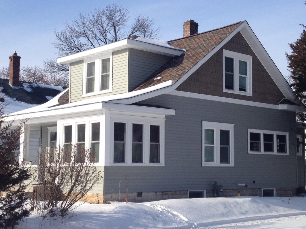 Completed gray lap siding and white trim on a Minnesota home in winter
