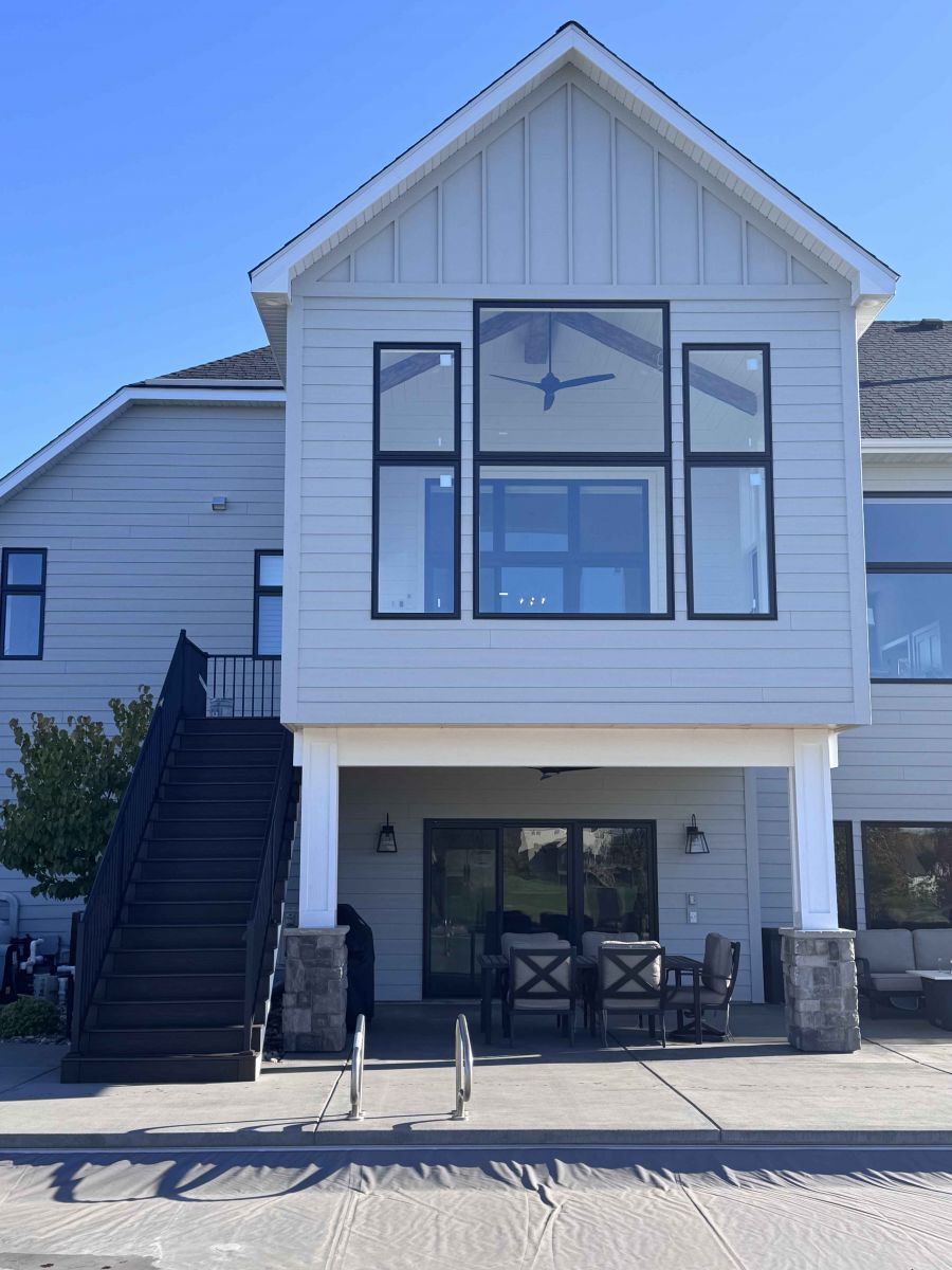 Four-season porch addition with large black-framed windows above a covered patio